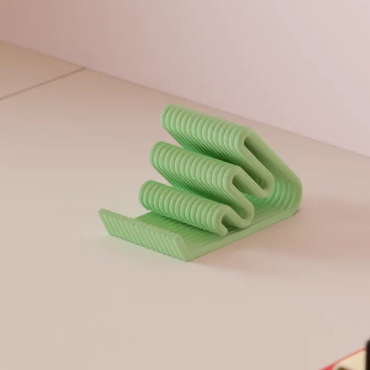 Green elastic band on a light pink surface with books in the background